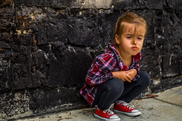 little beautiful girl near brick wall