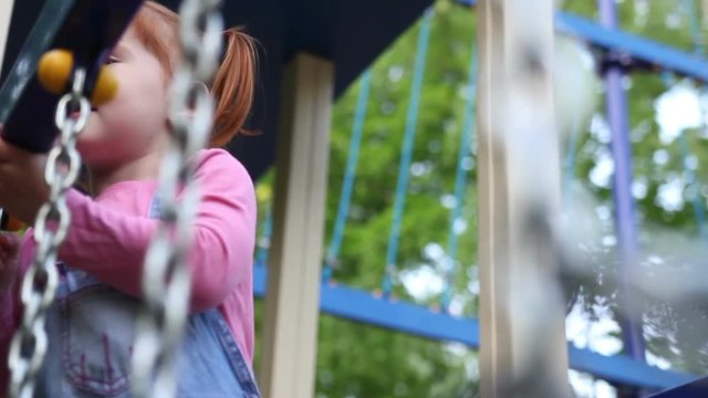 Redhead Little Girl Plays On Playground