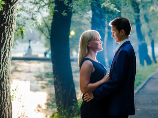 Couple hugging on the background of the pond in the park