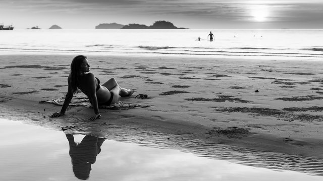 Beautiful young woman on the beach. Black and white photo.