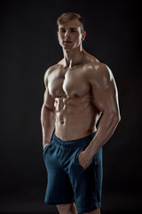 Obraz na płótnie Canvas Muscular bodybuilder guy doing posing over black background