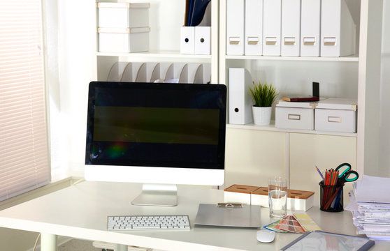 Designer working desk with computer and paperwork