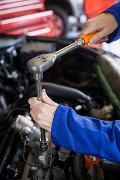 Mechanic servicing car engine