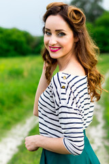 Naklejka premium Beautiful young girl in retro style walks in the meadow