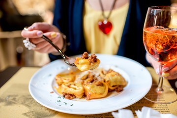 Eating a dish with traditional ring-shaped pasta tortellini and spritz aperol drink © rh2010