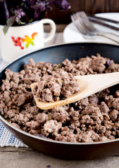 Pan with minced meat. Mug  with basil.
