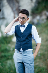 Funny thoughtful man in blue waistcoat stands in the garden