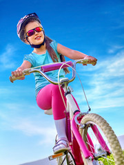 Obraz premium Girl bicycling child. Girl child rides bicycle. Little girl in cycling. Bicycling is good for child health. Cyclist look away. Bottom view.