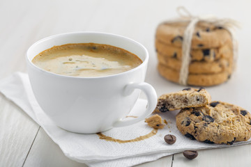Cup of coffee on a napkin with biscuits for dessert.  Coffee break with chocolate cookies.