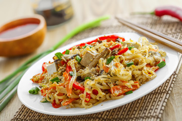Asian food. Fried rice noodles with tofu, vegetables and shiitake mushroom. Oriental cuisine meal.