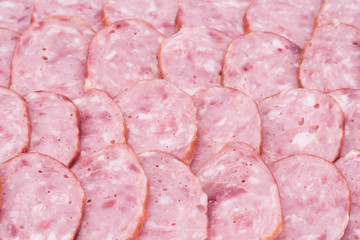Slices of salami on salami background.