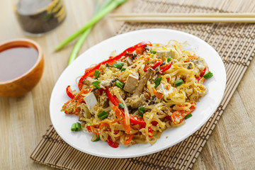 Stirred rice noodles with vegetables, tofu and shiitake mushroom. Traditional Asian food.