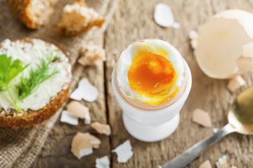 Traditional breakfast with perfect soft boiled egg and sandwich with butter and dill. International cuisine food. Top view.
