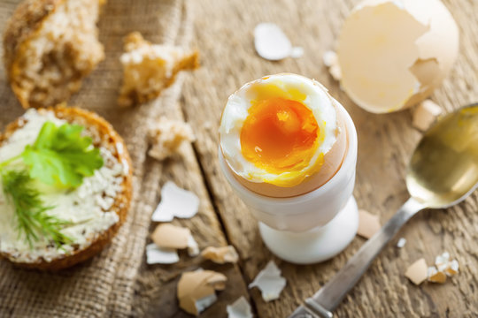 Breakfast with perfect soft boiled egg and sandwich with cheese. Traditional homemade food.