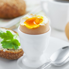 Perfect soft boiled egg, bread and butter with coffee for breakfast. Traditional healthy food.