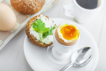 Perfect soft boiled egg, bread and butter with coffee for breakfast. Traditional healthy food. Top view.