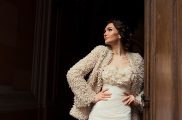 Sun shines over the beautiful woman in beige evening gown standi