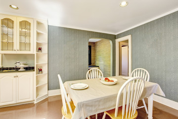 Dining area with table set in white tones and tile floor
