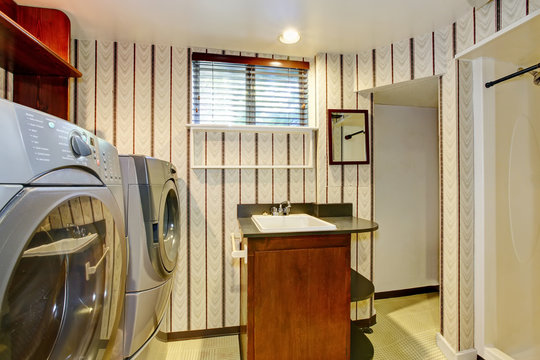 Old style laundry room with modern appliances and vintage wallpaper.