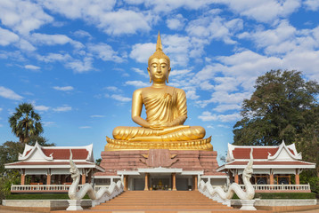 Fototapeta premium big golden buddha statue sitting in thai temple with blue sky background