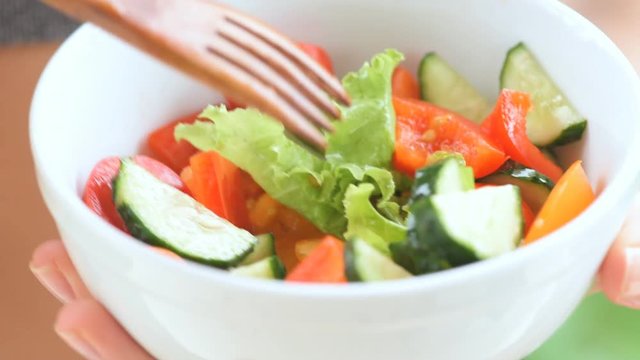 Young girl eating a vegetable salad after a workout . Fitness and healthy lifestyle concept.