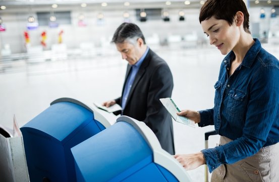 Business people using self service check-in machine