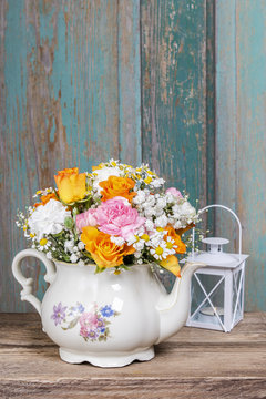 Romantic bouquet of flowers in vintage kettle