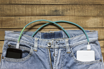 power bank lies in a back pocket of jeans, in the other is a mob