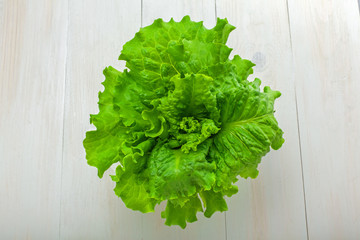 Fresh lettuce. Healthy vegetarian food on a white wooden table. Abstract concept. Top view, close-up.
