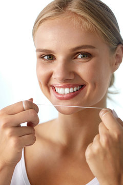 Dental Care. Woman With Beautiful Smile Using Floss For Teeth. High Resolution Image