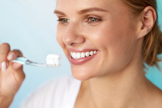 Woman With Beautiful Smile Brushing Healthy White Teeth. High Resolution Image