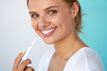 Woman With Beautiful Smile, Healthy Teeth Using Whitening Pen. High Resolution Image