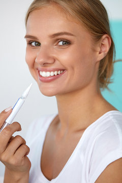 Teeth Whitening. Beautiful Woman Using Teeth Whitening Pen. High Resolution Image
