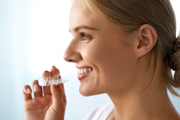 Smiling Woman With Beautiful Smile Using Invisible Teeth Trainer. High Resolution Image