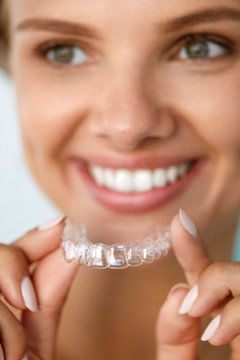 Smiling Woman With White Teeth Holding Teeth Whitening Tray. High Resolution Image