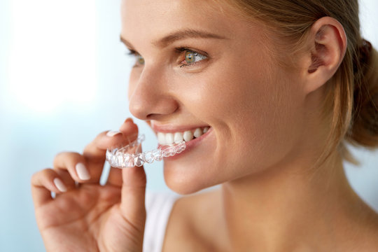 Smiling Woman With Beautiful Smile Using Invisible Teeth Trainer. High Resolution Image