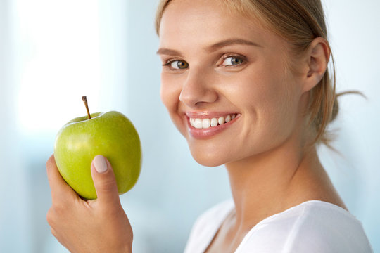 Woman With Apple. Beautiful Girl With White Smile, Healthy Teeth. High Resolution Image