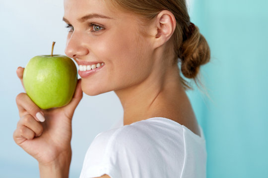 Happy Woman With Beautiful Smile, Healthy Teeth Holding Apple. High Resolution Image