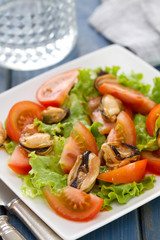 salad with tomato and mussels on white dish