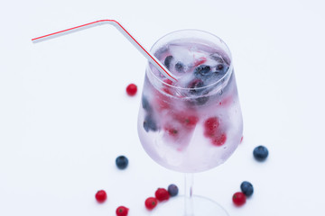 A Glas With Ice Cubes and Frozen Berries