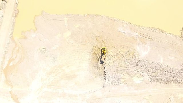 Camera flight over a working excavator in the mine. Industrial footage on mining theme. Heavy industry in Central Europe.