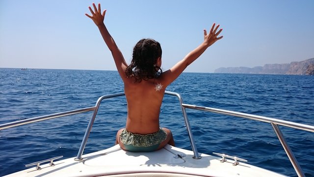 Ni&ntilde;a sentada en la proa del barco