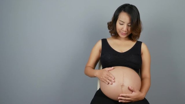 Beautiful pregnant woman on gray background