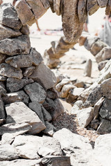 Unusual piles of stones of different sizes. Unequal stones glued together in the park. 