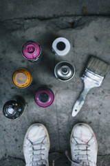 Spray paint cans and brush on sidewalk   © yossarian6