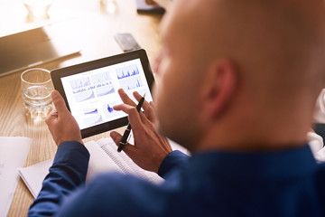 Portable computer tablet being used by a caucasian male business executive during a board meeting...