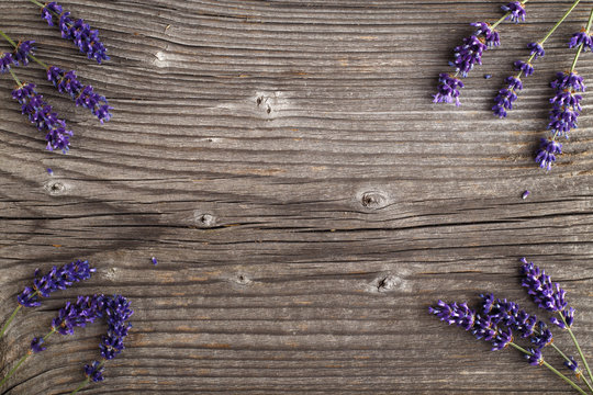 Fototapeta Lavender flowers on a wooden background. Floral border or frame