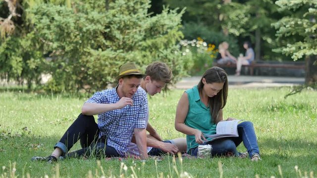 Students Are Sitting on a Lawn Reading Studying Young People Girl Boys Preparing to Exams Doing the Hometask Have a Good Time at the Nature College Campus