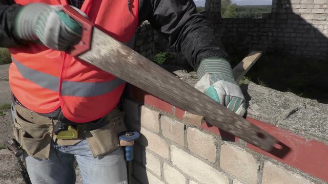 Construction worker using handsaw
