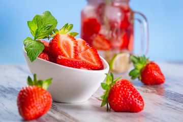 Strawberries in a bowl on wooden table